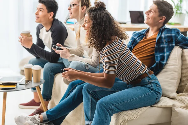 Muchachas adolescentes multiétnicas jugando videojuego en casa - foto de stock