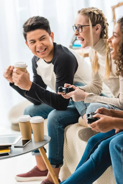 Laughing multiethnic teenagers playing video game — Stock Photo