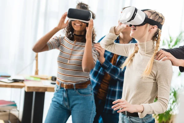 Glückliche multikulturelle Teenager-Mädchen, die etwas mit Virtual-Reality-Headsets ansehen — Stockfoto