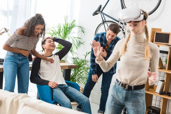 Amici multiculturali ridendo di ragazza in cuffia realtà virtuale — Foto stock