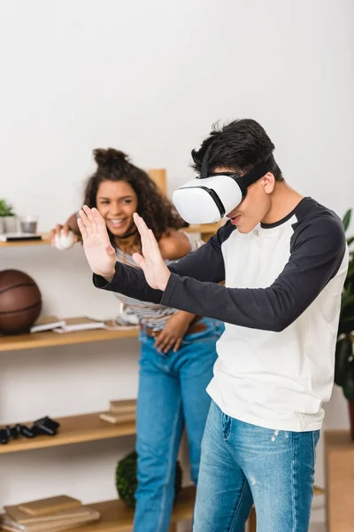 African american girl laughing of boy touching something with virtual reality headset — Stock Photo