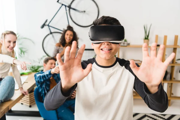 Excited teen boy touching something with virtual reality headset — Stock Photo