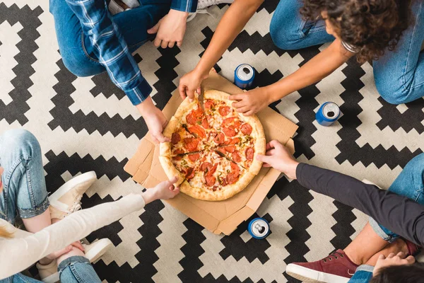 Cropped image of teens taking pizza pieces — Stock Photo