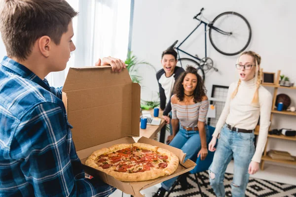 Adolescente menino mostrando amigos cheirando pizza — Fotografia de Stock