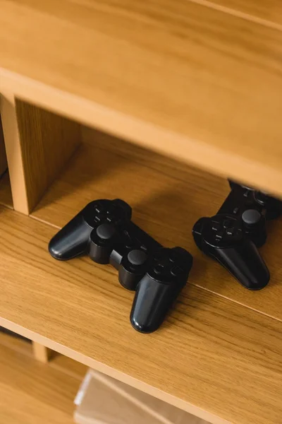 Overhead view of two game pads on wooden shelves — Stock Photo