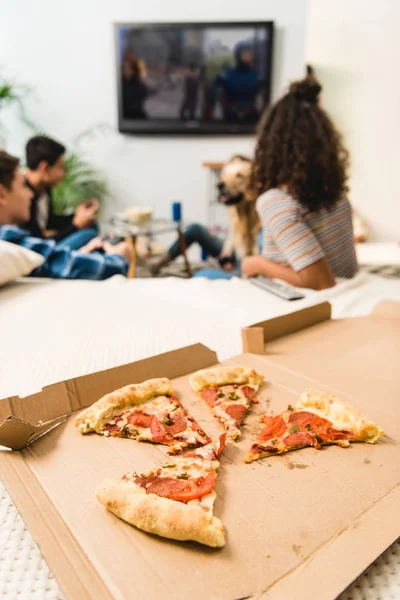 Adolescenti multiculturali che giocano al videogioco con pizza in primo piano — Foto stock