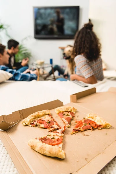 Подростки играют в видеоигры с пиццей на переднем плане — стоковое фото