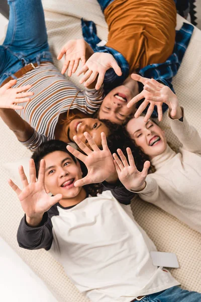 Vista aérea de adolescentes multiétnicos sonrientes saludando con las manos - foto de stock