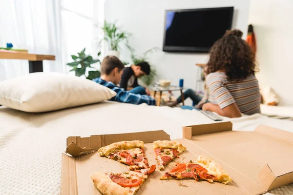 Amis regarder la télévision avec pizza au premier plan — Photo de stock