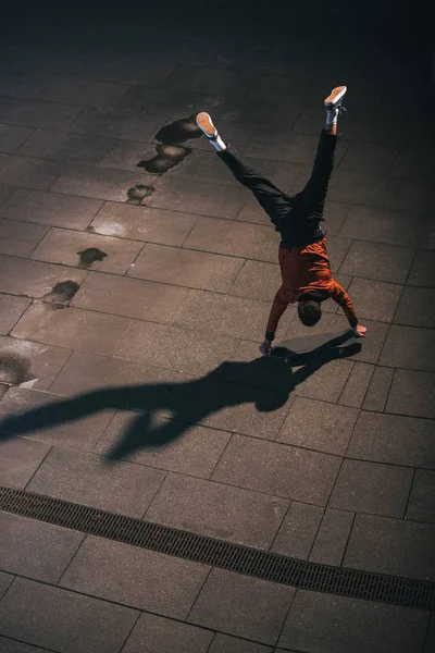 Vista ad alto angolo di skateboarder cavalcando a testa in giù sulle mani — Foto stock