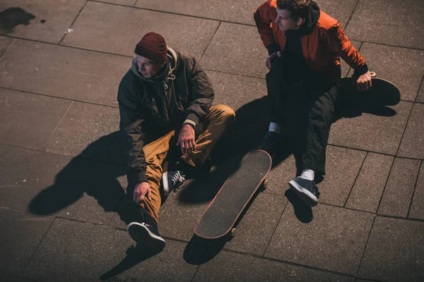 Blick aus der Vogelperspektive auf Skateboarder, die entspannt auf dem Boden sitzen — Stockfoto