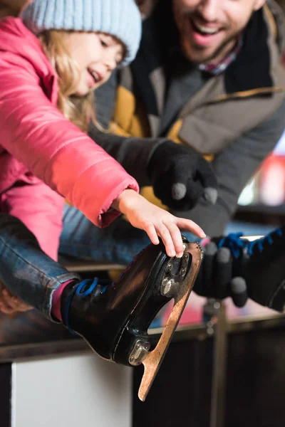 Вибірковий фокус щасливого батька і дочки в ковзанах на ковзанах — стокове фото