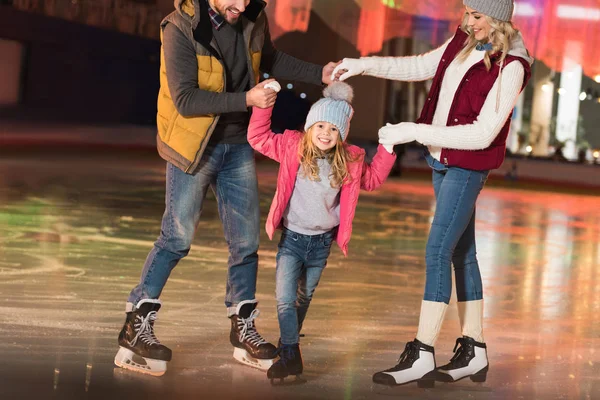 Plan recadré de parents heureux enseignant adorable petite fille patiner sur la patinoire — Photo de stock