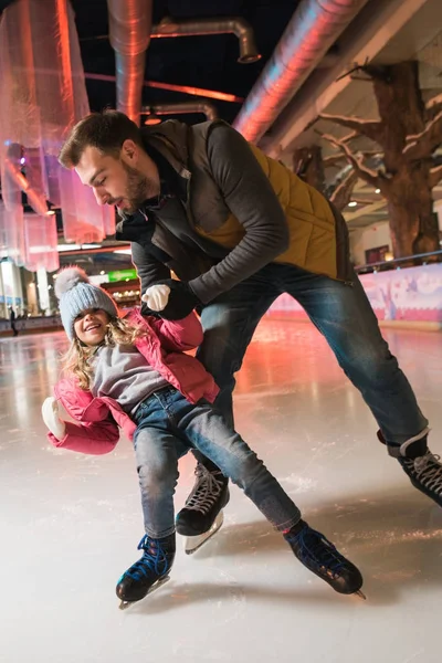 Père enseignement mignon petite fille patinage sur patinoire — Photo de stock