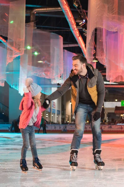 Glücklicher Vater und Tochter beim gemeinsamen Schlittschuhlaufen auf der Eisbahn — Stockfoto
