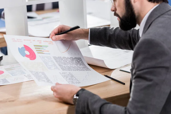 Geschnittenes Bild eines Geschäftsmannes beim Betrachten von Dokumenten im Amt — Stockfoto