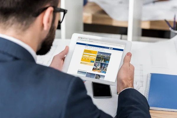 Geschäftsmann hält Tablet mit geladener Buchungsseite — Stockfoto