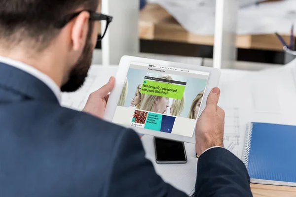 Businessman holding tablet with loaded bbc science page — Stock Photo