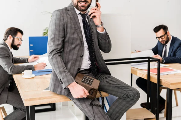 Abgeschnittenes Bild eines Geschäftsmannes, der im Büro mit einem stationären Telefon telefoniert — Stockfoto
