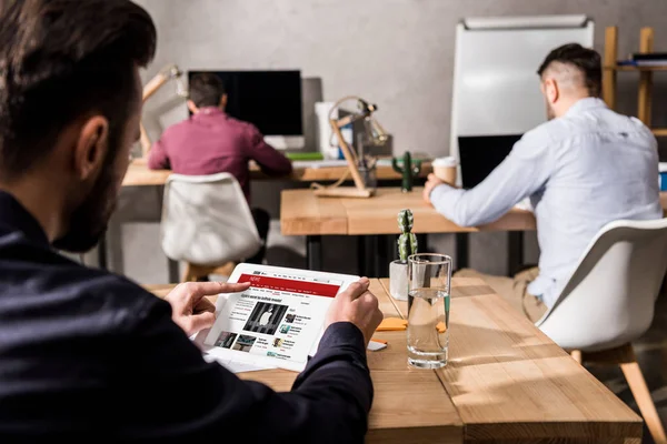 Businessman holding tablet with loaded bbc news page — Stock Photo