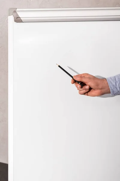 Cropped image of businessman showing something at flipchart — Stock Photo