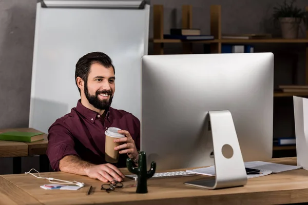 Uomo d'affari sorridente che lavora al computer in ufficio — Foto stock