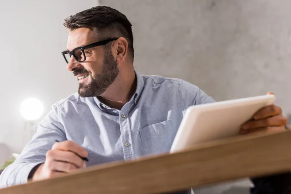 Lächelnder gutaussehender Geschäftsmann, Tablet in der Hand und wegschauend — Stockfoto