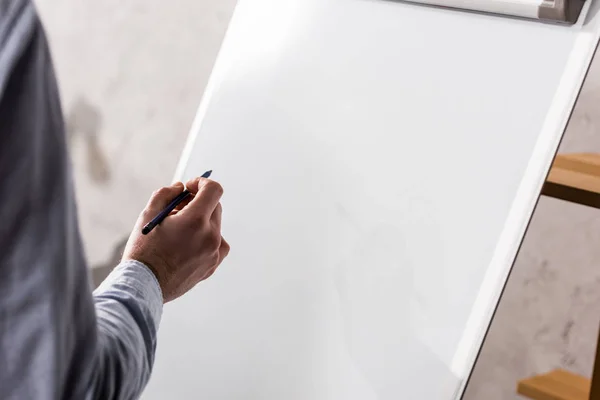 Immagine ritagliata di uomo d'affari che scrive qualcosa su flipchart — Foto stock