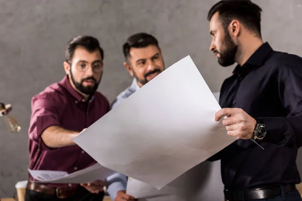 Arquitectos mirando planos en el espacio de trabajo - foto de stock