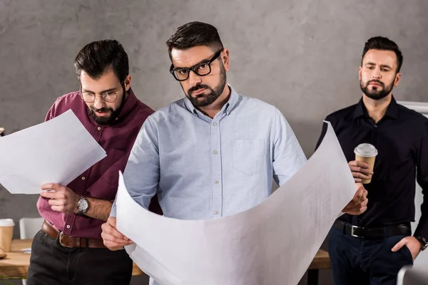 Handsome caucasian architects with blueprints in office — Stock Photo