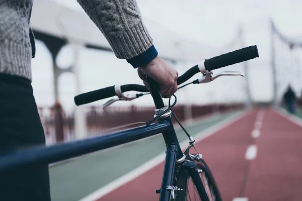 Colpo ritagliato di uomo con bicicletta sul ponte pedonale — Foto stock