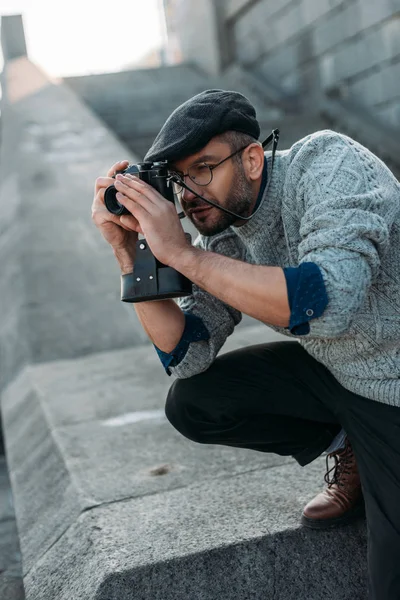 Schöner erwachsener Mann, der Foto mit Vintage-Filmkamera im Freien macht — Stockfoto