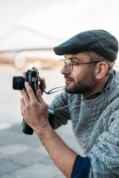 Hombre adulto con estilo con cámara de película vintage al aire libre - foto de stock