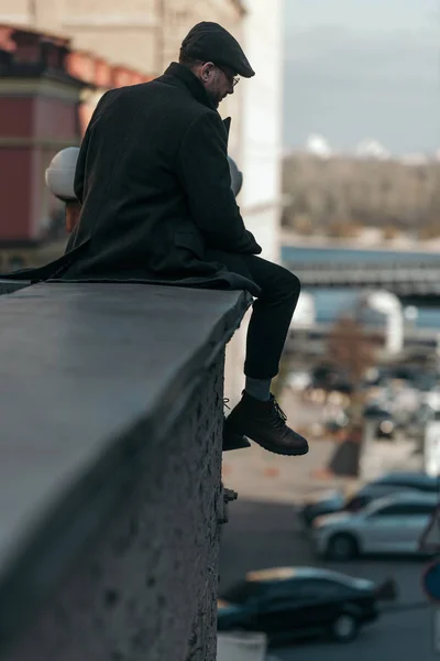 Apuesto hombre de mediana edad sentado en el techo del edificio - foto de stock