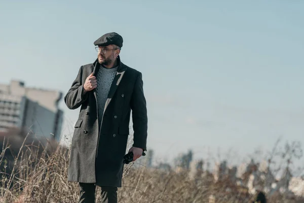 Bel homme d'âge moyen en manteau marchant à l'extérieur — Photo de stock