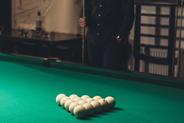 Imagem cortada do homem que está atrás da mesa de bilhar de jogo com conjunto de bolas de piscina russas — Fotografia de Stock