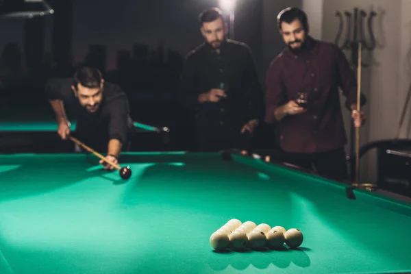 Homem bonito de sucesso jogando na piscina no bar com amigos — Fotografia de Stock