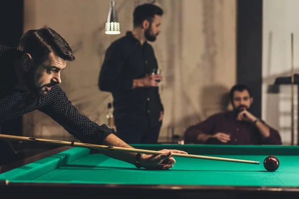 Exitoso hombre guapo jugando en la piscina en el bar con amigos - foto de stock