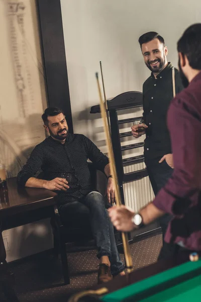 Compañía de hombres felices con bebidas y señales en el bar de billar - foto de stock