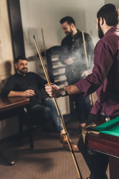 Compañía de hombres felices con bebidas y señales en el bar de billar - foto de stock