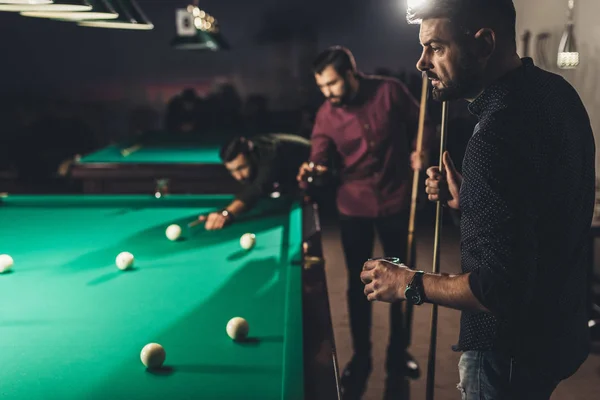 Companhia de homens bonitos jogando na piscina no bar — Fotografia de Stock