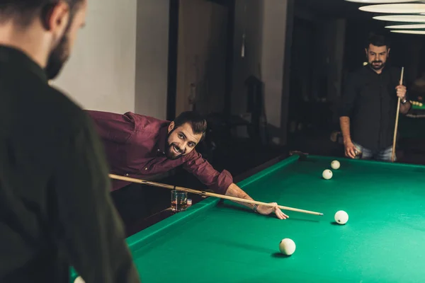 Companhia de homens bonitos jogando na piscina no bar — Fotografia de Stock