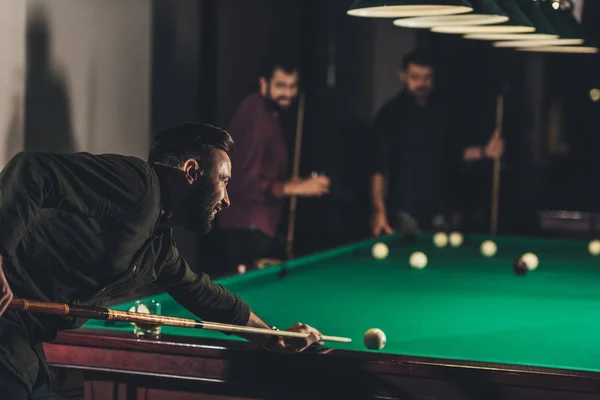 Company of successful handsome men playing in pool at bar — Stock Photo
