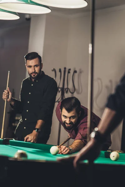 Company of successful handsome men playing in pool at bar — Stock Photo