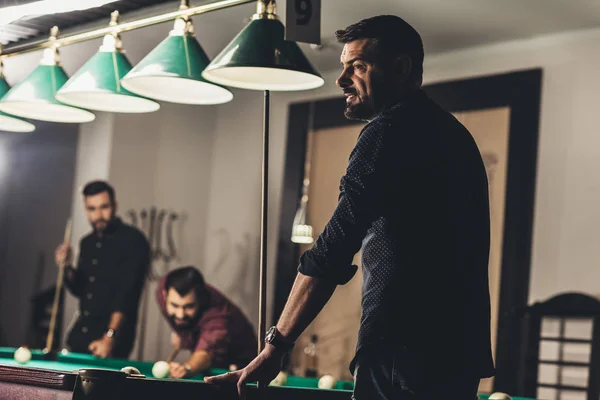 Company of successful handsome men playing in pool at bar — Stock Photo