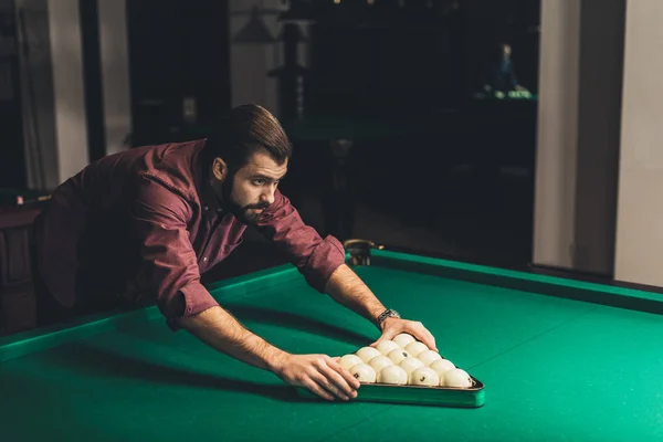 Bonito homem formando triângulo de russo piscina bolas no bar — Fotografia de Stock