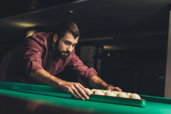 Handsome man forming triangle of russian pool balls at bar — Stock Photo