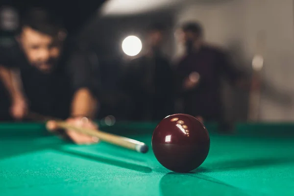 Junger erfolgreicher schöner Mann spielt in russischem Pool an Bar mit Freunden — Stockfoto