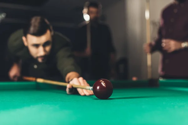 Junger erfolgreicher schöner Mann spielt in russischem Pool an Bar mit Freunden — Stockfoto