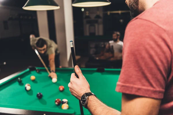 Hombre caucásico al lado de la mesa de billar en el bar con amigos - foto de stock